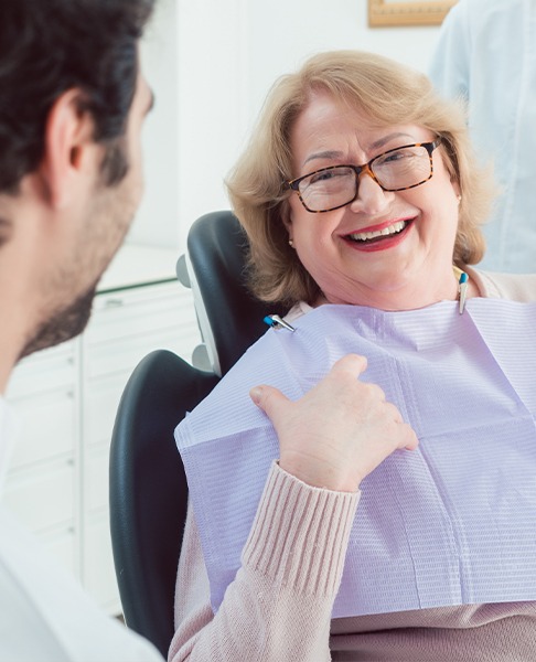Periodontist and patient laughing together in the exam room