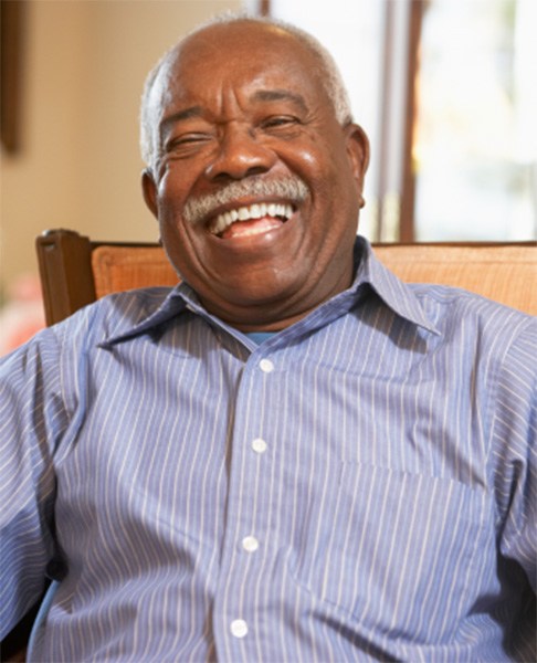 Senior man sitting in chair and laughing