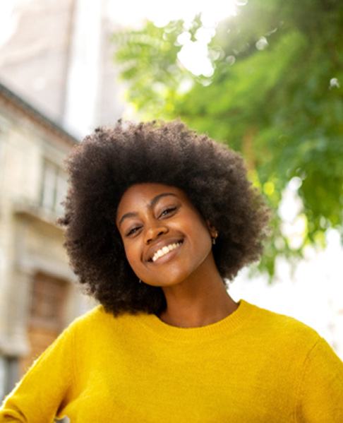 Woman outside smiling with dental implants in Dallas, TX