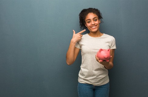 Someone holding a piggy bank an pointing at their smile