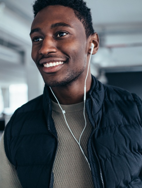 Man with earbuds smiling