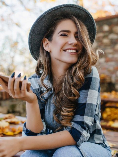 Woman in plaid shirt smiling outdoors