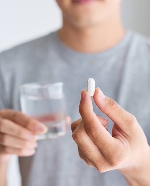 Man holding antibiotic pill