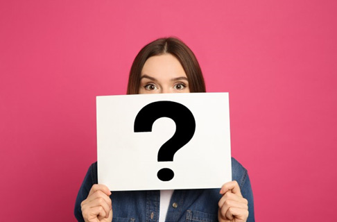 Woman holding up card with a question mark