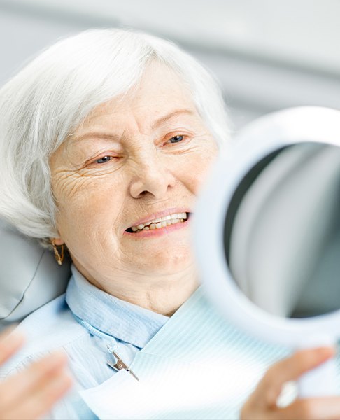 Woman looking at her smile after pocket reduction surgery