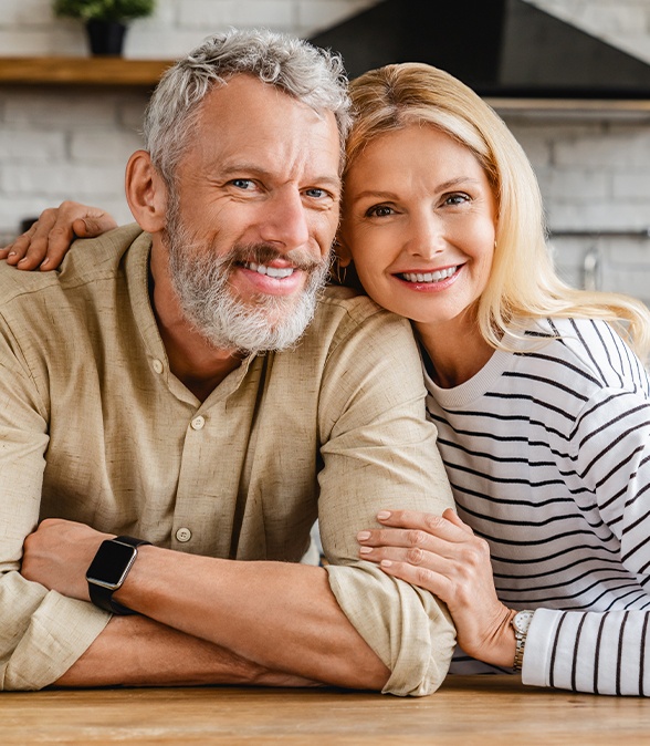 Man and woman smiling after periodontic treatment