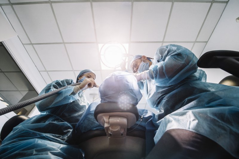 Dentists performing dental implant surgery on a patient