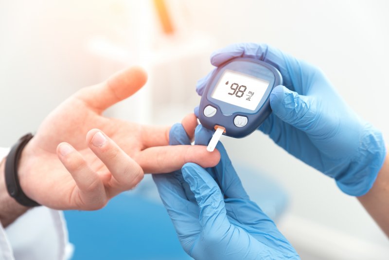 Healthcare worker testing blood of patient with diabetes